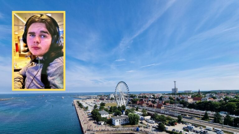 Aerial view of a coastal port city with a Ferris wheel and buildings near the shoreline. Inset image of a person wearing headphones in the top left corner, possibly related to the search for a missing American teenage boy located 100 miles away.