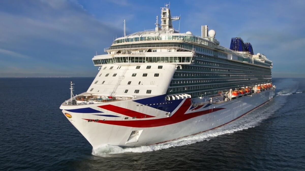 A large P&O cruise ship, proudly displaying the UK flag on its bow, sails through calm waters on a clear day.