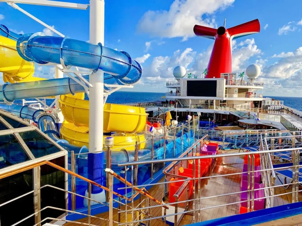 A cruise ship with a water slide on the deck, offering Carnival's drink package.