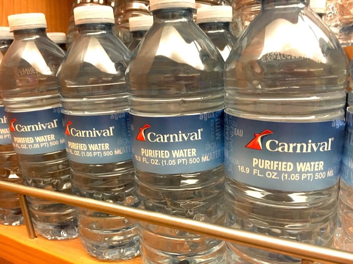 Four bottles of Carnival branded purified water are arranged in a row on a shelf. Each bottle holds 16.9 fl. oz. (500 ml) of water.