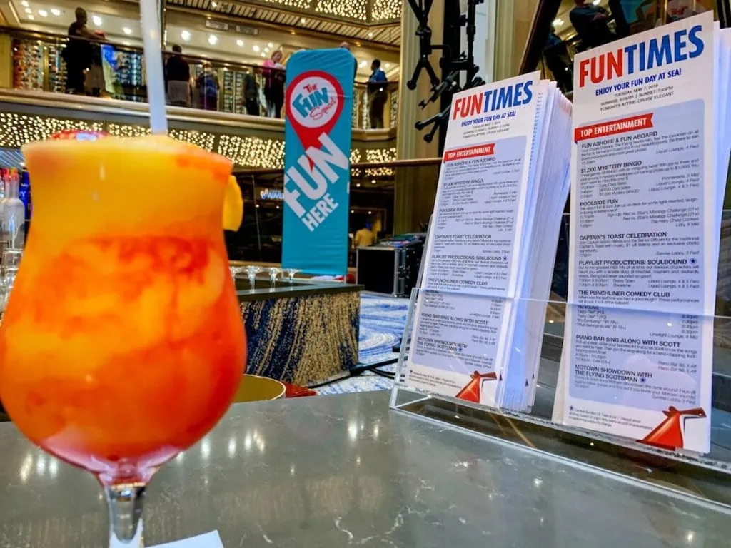 A drink package provided by Carnival is sitting on a table in front of a menu.