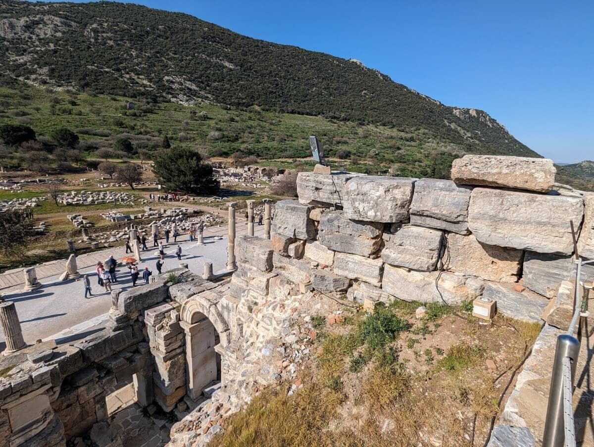 Ancient ruins with tourists exploring the historic site on a sunny day.