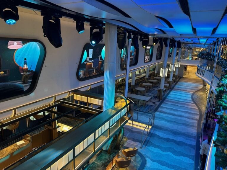 A view of the Carnival Jubilee cruise ship with a bar in the middle, inviting guests to explore and play.