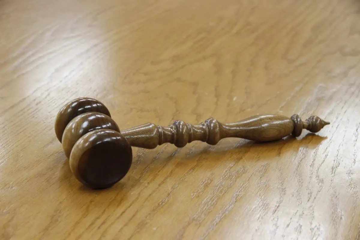 A wooden gavel rests on a table.