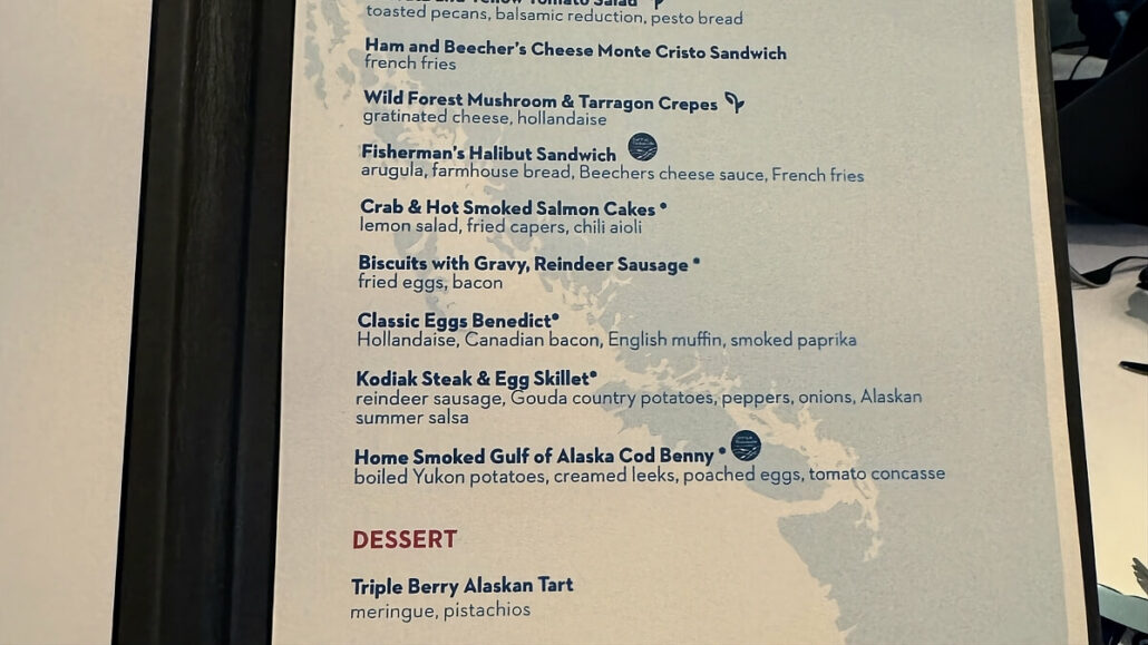 Menu featuring various breakfast items including Ham and Beecher's Cheese Monte Cristo Sandwich, Fisherman's Halibut Sandwich, Kodiak Steak & Egg Skillet, and Triple Berry Alaskan Tart for dessert. Perfect for those cruising the Inside Passage on their Alaska trip.