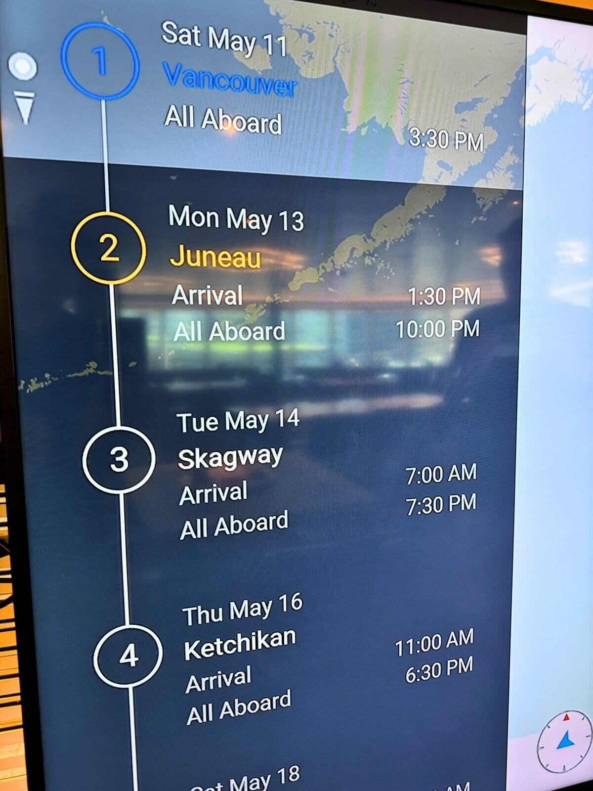 Digital display showing Holland America Koningsdam cruise itinerary with ports of call and arrival times for Vancouver, Juneau, Skagway, and Ketchikan.