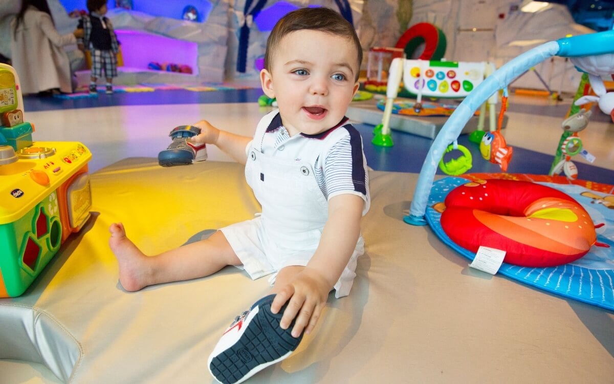 A baby sitting on a mat designed by one of the best cruise lines for babies and toddlers