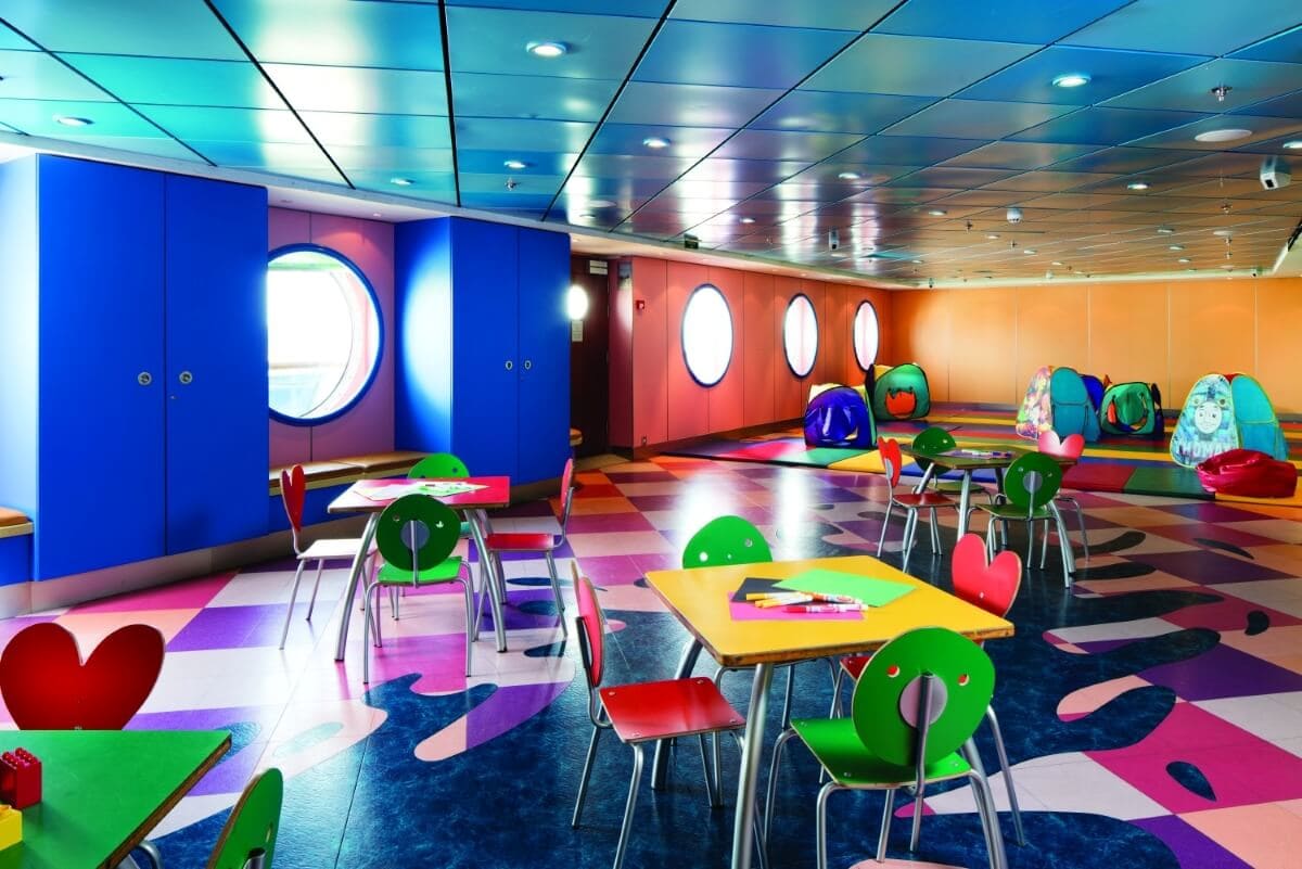 A brightly colored room with tables and chairs, perfect for families on the best cruise lines for babies and toddlers.